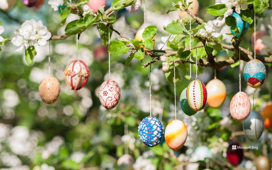 Many colorfully painted Easter eggs on an apple tree